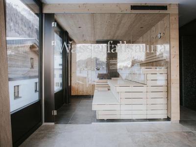 Moderner Spa-Bereich mit Holzverkleidung und Liegen in einem Hotelinterieur.