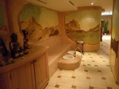 Flur mit cremefarbenem Fliesenboden, Wandmalereien und hölzernen Möbeln mit Dekoration.