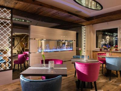 Eleganter Hotel-Loungebereich mit farbigen Stühlen und modernem Innenraumdesign.