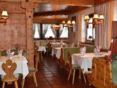 Rustic hotel restaurant with wooden furniture, white tablecloths, and cozy lighting.