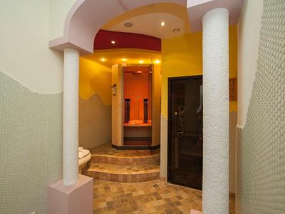 Interior of a hotel with colorful walls, columns, and a dark sauna room.