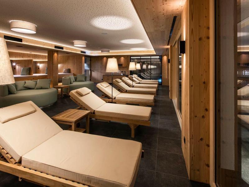 Ein stilvoller Ruheraum mit bequemen Holzliegen und warmem Licht für Entspannung.