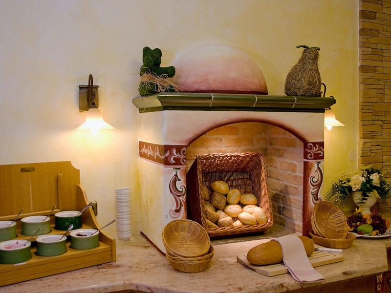Gemütlicher Kamin mit vielen Broten, Körben, Eimer und Töpfen in rustikalem Raum gekauft.