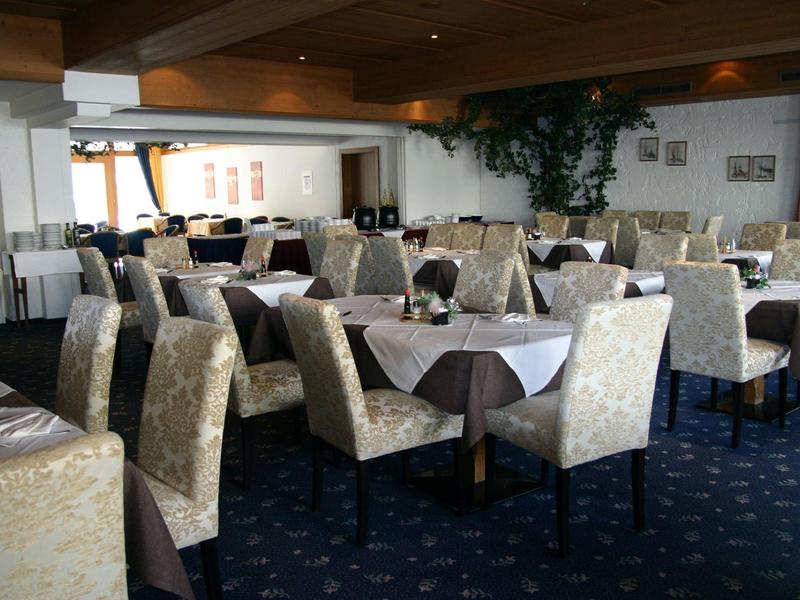 Großer Speisesaal mit eleganten Stühlen und Tischen, Teppichboden und gedeckten Tischen.