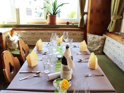 Przytulny stół w restauracji z nakryciem, kieliszkami do wina, serwetkami i kwiatową dekoracją przy oknie