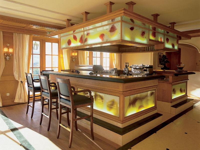 Eleganter Barbereich mit Holzstühlen und beleuchteten, floralen Dekorelementen in warmem Licht.