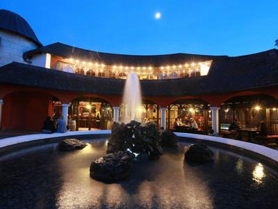 Hôtel avec fontaine éclairée et ciel au clair de lune en soirée