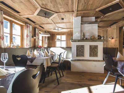 Gemütliches Restaurant mit Holzbalkendecke und weißen Tischdecken in den Bergen.