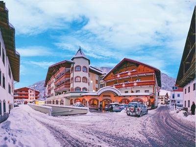 Edificio dell'hotel con parcheggio innevato e cielo azzurro in inverno