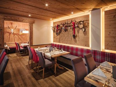 Ristorante accogliente con pareti in legno, rivestimenti a quadri e tavoli apparecchiati.