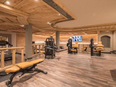 Gimnasio moderno con techo de madera y varias máquinas de ejercicio