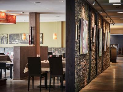 Innenraum eines modernen Restaurants mit gedeckten Tischen und Kunst an der Wand.