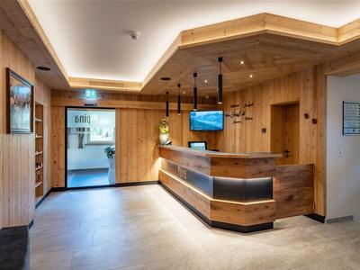 Moderner Hotel-Empfangsbereich mit Holzvertäfelung und Empfangstresen.
