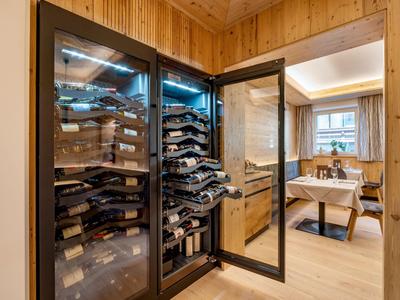 Moderner Weinkühlschrank in einem hölzernen Hotelzimmer mit Essbereich.