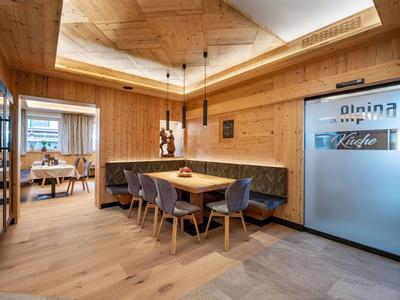 Gemütlicher Essbereich mit Holztisch, Sesseln und integrierter Bank in modernem Hotelinterieur.