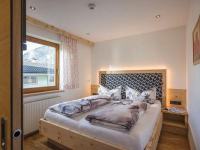 Helles Hotelzimmer mit Doppelbett, Holzverkleidung und einem großen Fenster mit Ausblick.