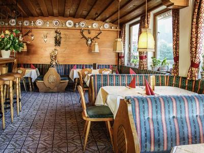 Gemütliches Restaurant mit Holzwänden, traditionellen Vorhängen, bunten Stoffen und Hirschgeweihen.