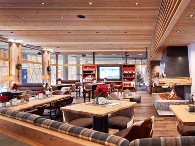 Gemütliches Restaurant mit Holztischen, gepolsterten Bänken und warmem Kaminfeuer.