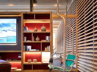 Moderner Raum mit Holzlamellen, bunter Schaukel und beleuchtetem Regal mit Dekoration.