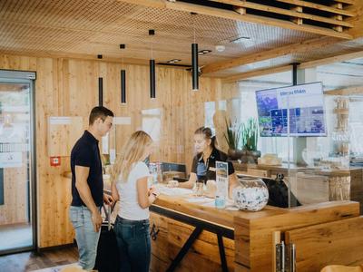 Two guests are checking in at the reception in a modern wooden interior hotel.