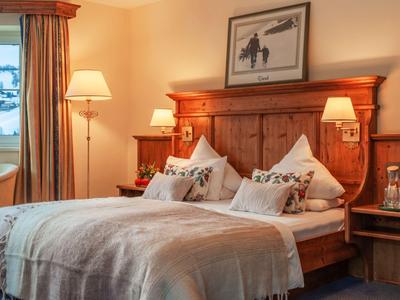 Cozy hotel room with double bed, wooden furniture, and warm lighting