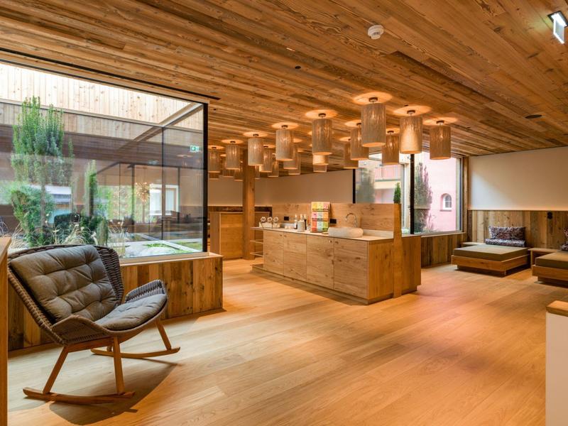 Modern eingerichteter Hotel-Loungebereich mit Holzboden und großen Fenstern zum Innenhof