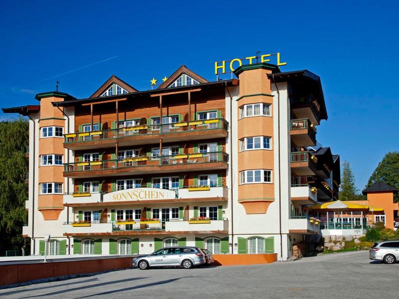 Mehrstöckiges Hotelgebäude mit Balkonen und gelbem HOTEL-Schild bei klarem Himmel.