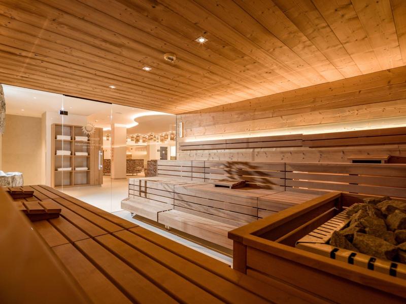 Helle Sauna mit Holzbänken und Dampfgenerator in einem modernen Hotel.
