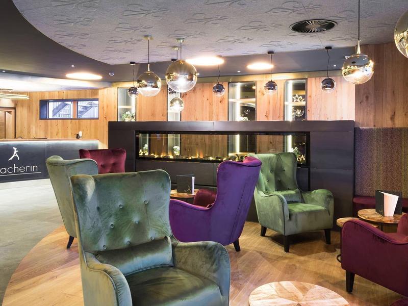 Modern eingerichtete Hotellobby mit stilvollen Sesseln und einer Rezeption im Hintergrund.