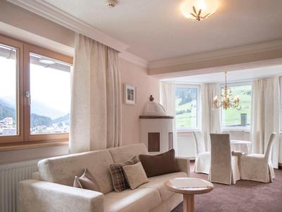 Bright living room with sofa, fireplace, and mountain view through window.