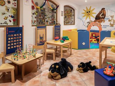 Cozy children's play area with wooden furniture, toys, and colorful decorations in warm lighting.