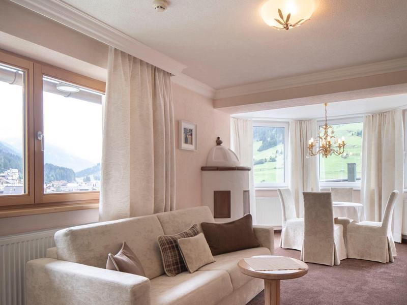 Bright living room with sofa, fireplace, and mountain view through window.
