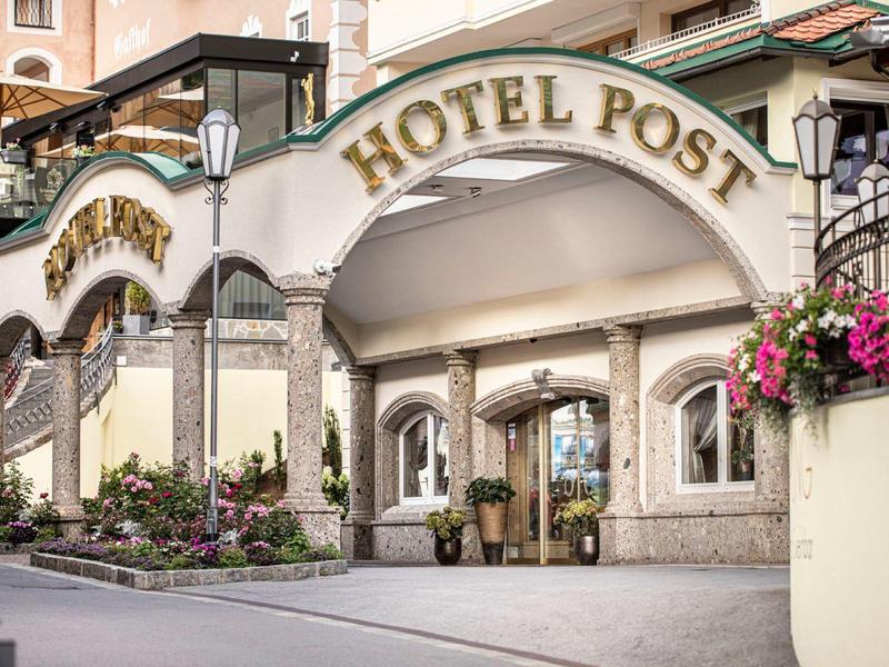 Entrance to Hotel Post with archway, floral arrangements, and seating areas.