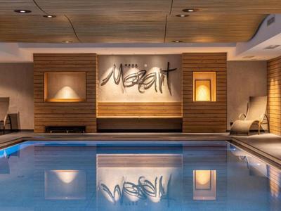 Innenpool mit modernen Holzverkleidungen und gemütlicher Beleuchtung in einem Hotel.