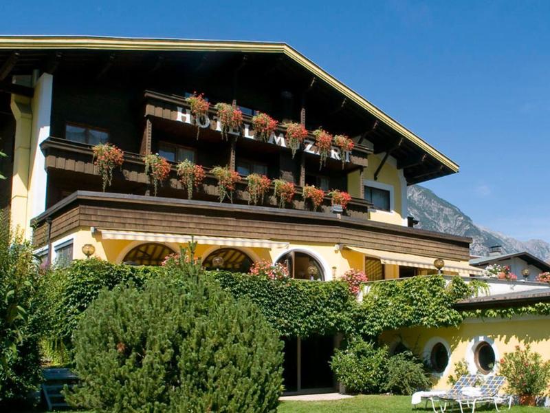 Traditionelles Hotelgebäude mit Balkonblumen und Bergen im Hintergrund