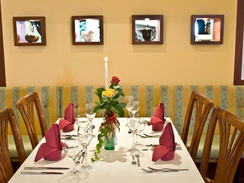 Elegantes Restaurant mit gedecktem Tisch, roten Servietten und Blumenarrangement.