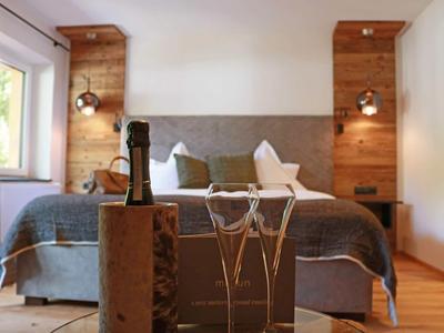 Cozy bedroom with wooden accents, large bed, and modern lamps.