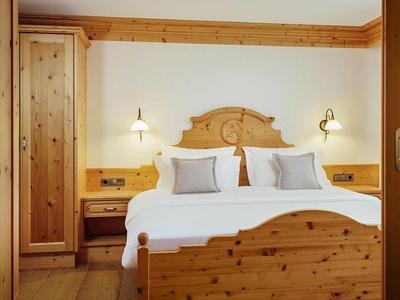 Cozy hotel room with double bed and rustic wooden furniture.