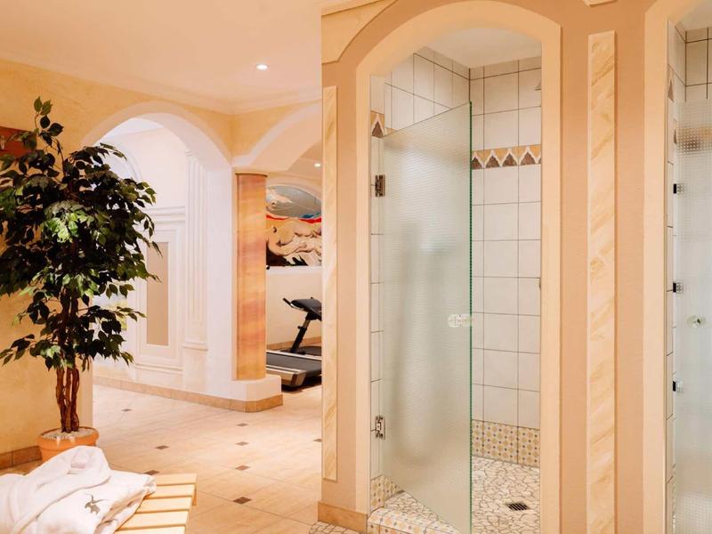 Bright, elegant bathroom with shower, towels, and a plant in a hotel.