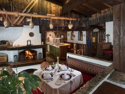 Útulná jídelna s rustikálním krbem a dřevěným stropem v venkovském hotelu.
