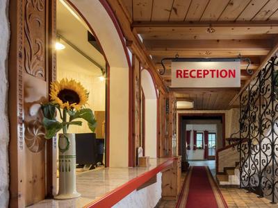 Interiér recepce s vázičkou a slunečnicí na přepážce.