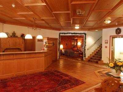 Gemütlicher holzinterieur Empfangsbereich mit Teppichen, Treppe und warmem Licht.