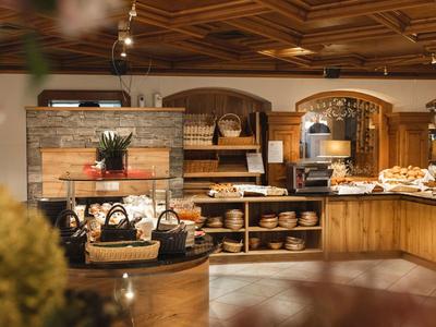 Gemütlicher Frühstücksbereich mit Backwaren und Holzmöbeln in einem Hotel.
