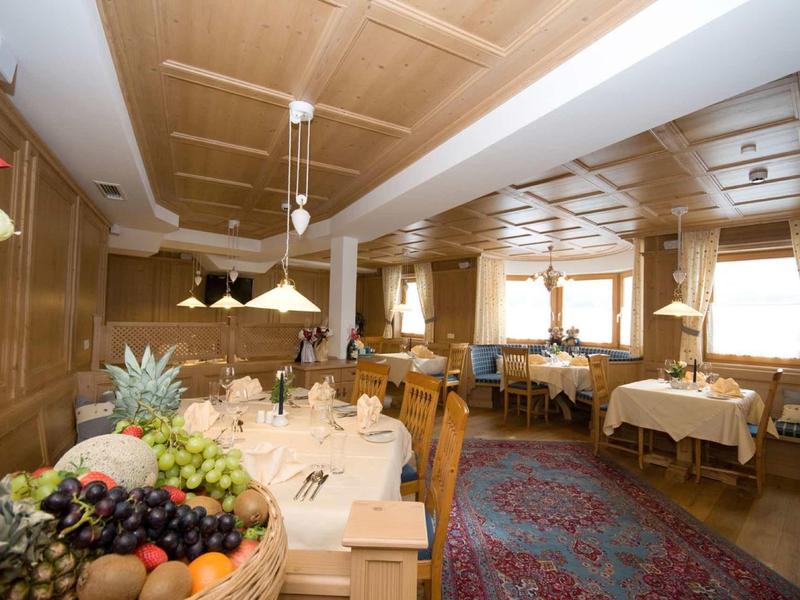 Helles Restaurant mit Holztäfelungen, gedeckten Tischen und buntem Teppichboden.