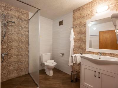 Nowoczesna łazienka z prysznicem, toaletą i umywalką z lustrem w ciepłych kolorach