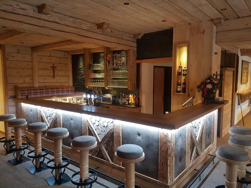 Gemütliche Holzbar mit LED-Beleuchtung, Rundhockern und rustikalem Ambiente.