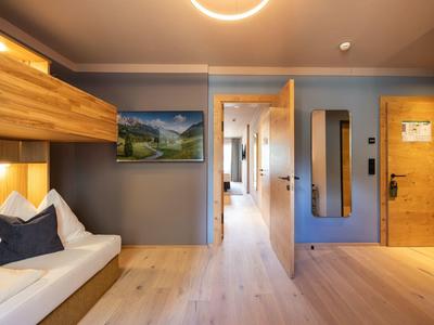 Moderner Hotelzimmerflur mit Holztüren und bequemen Sitzgelegenheiten mit Kissen.