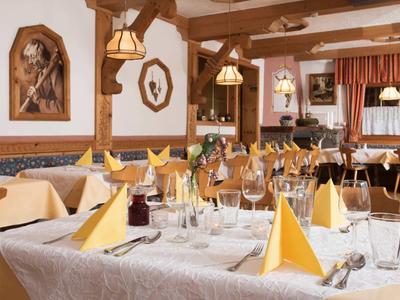 Sala da pranzo elegante con tavoli apparecchiati e tovaglioli gialli in uno spazio accogliente.