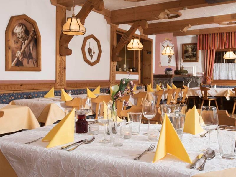 Cozy dining room with set tables and wood-paneled walls in a hotel.