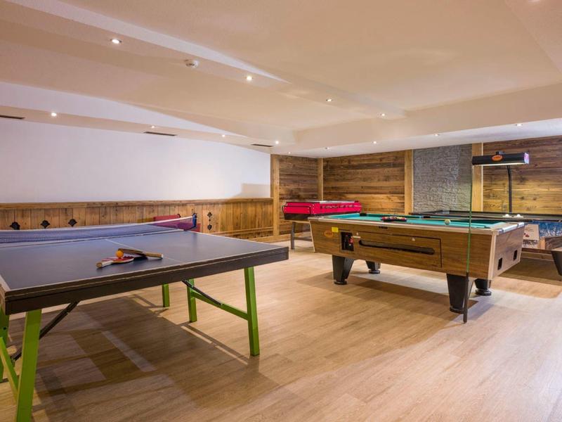 Freizeitraum mit Tischtennis-, Billard- und Airhockey-Tischen auf hellem Holzboden.